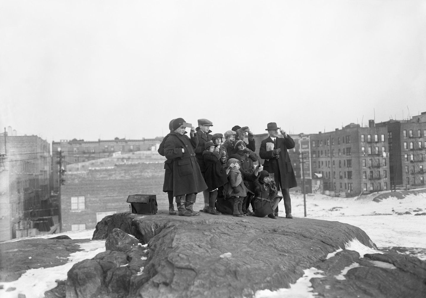 Gruppe von Menschen steht auf Felsen und blickt in den Himmel