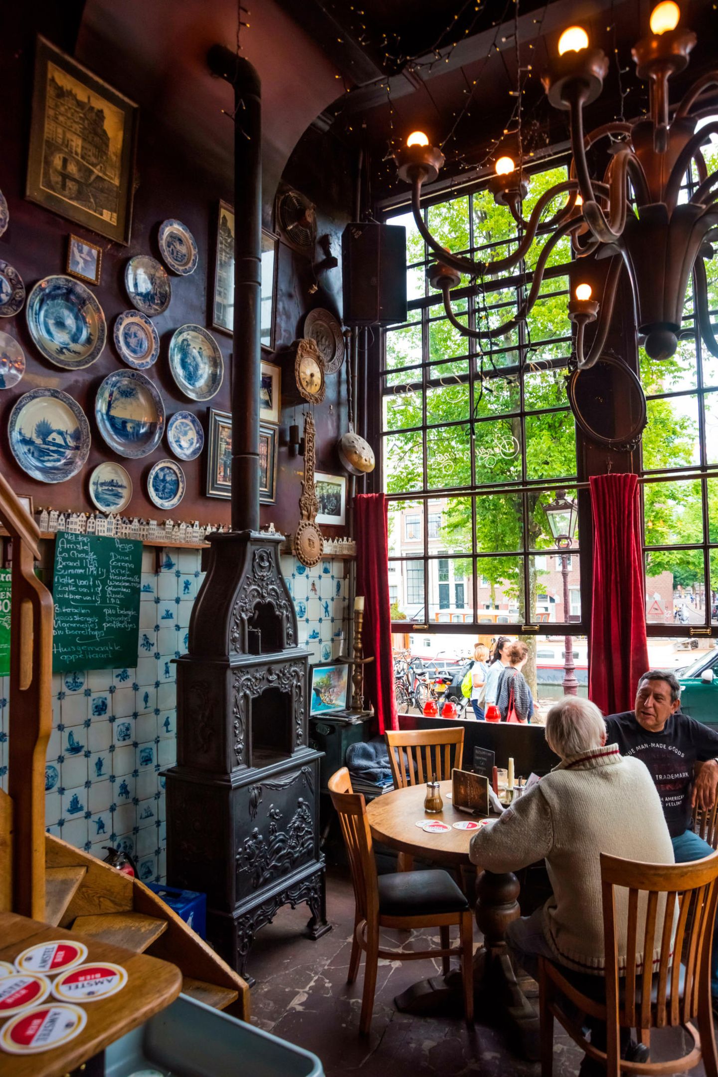 Das Geheimnis um das Café Papeneiland in Amsterdam gemütliches Café mit hohen Fesntern und Delft-Tellern an den Wänden