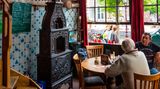 gemütliches Café mit hohen Fesntern und Delft-Tellern an den Wänden
