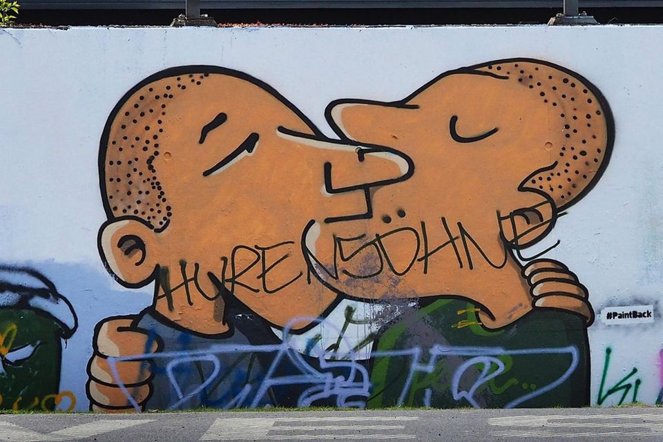 Schriftzug "Hurensöhne" prangt auf einem Graffiti, das küssende Männer zeigt 0.7915