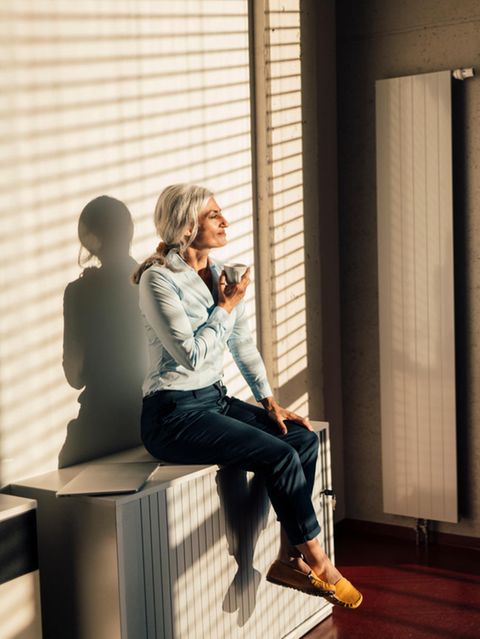 Frau schaut aus dem Fenster