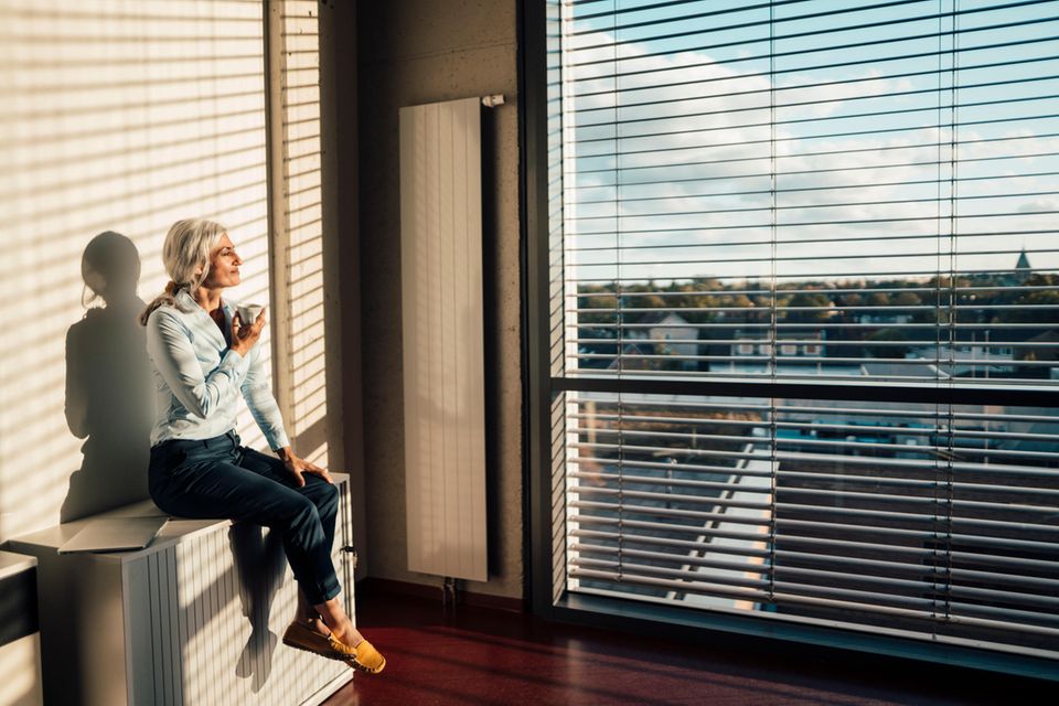 Frau schaut aus dem Fenster 1.4993
