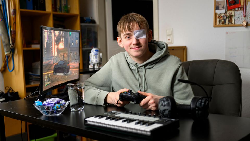 16-Jähriger sitzt am Schreibtisch und spielt mit seiner X-Box