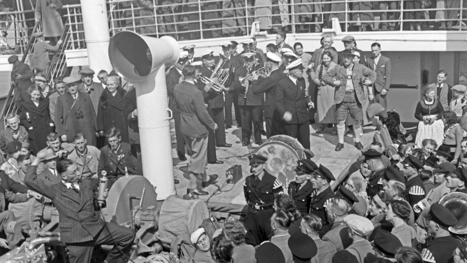 Viele Menschen stehen an Deck der "Wilhelm Gustloff", in der Mitte musiziert eine Band mit Blasinstrumenten