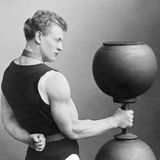 Ein muskulöser Mann hält eine überdimensionierte Hantel