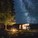 Familie mit Camping-Truck sitzt am Lagerfeuer im russichen Altai