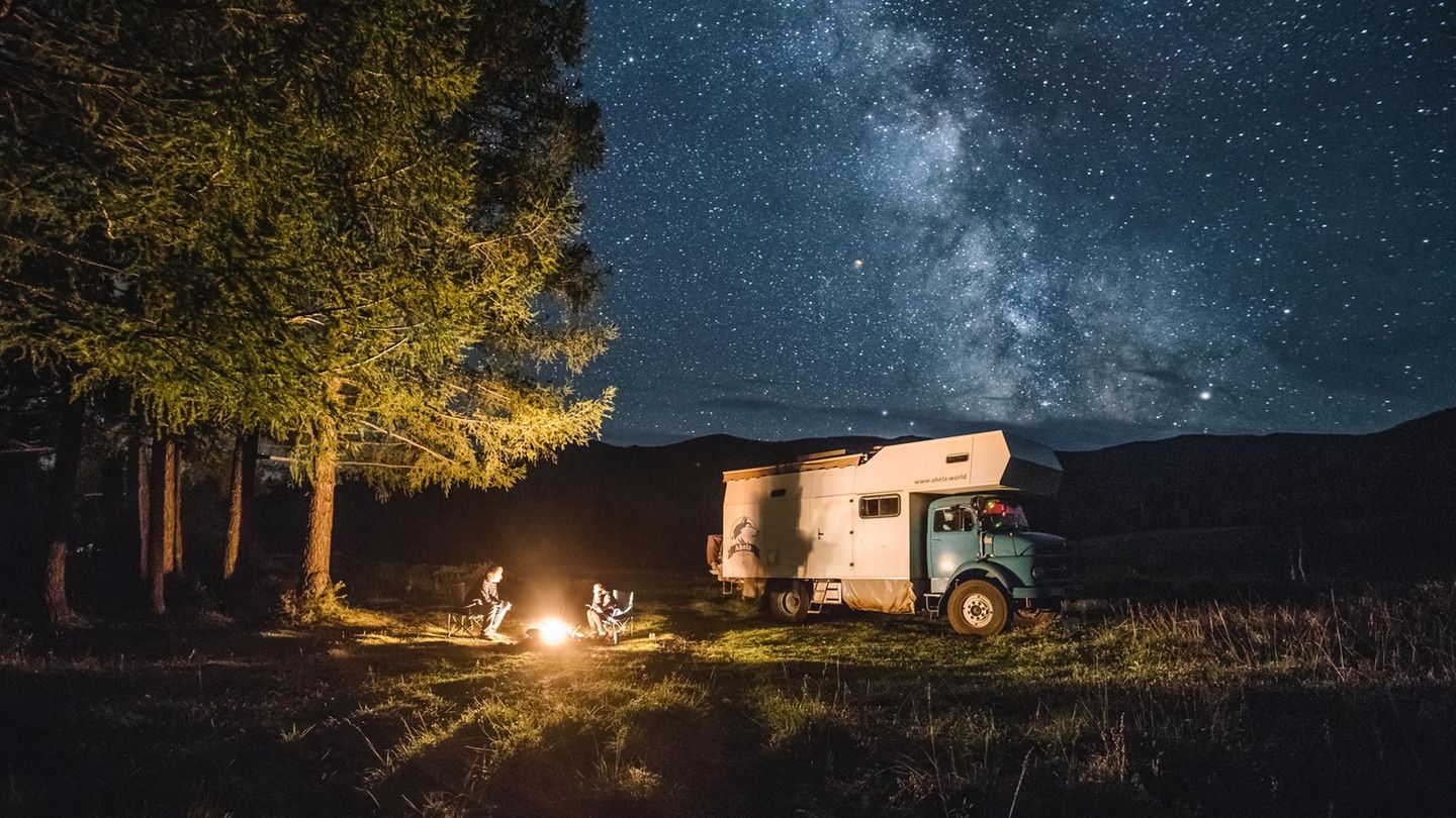 Camping unter den Sternen Familie mit Camping-Truck sitzt am Lagerfeuer im russichen Altai