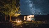 Familie mit Camping-Truck sitzt am Lagerfeuer im russichen Altai