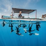Wie eine Gruppe von Spidermen schweben diese Freitaucher kopfüber unter einem Boot im kristallklaren Wasser. Unterwasserfotografin Wan Yong Chong vereint in ihren Bildern die Eleganz menschlicher Bewegung mit der fließenden Schönheit des Meeres.