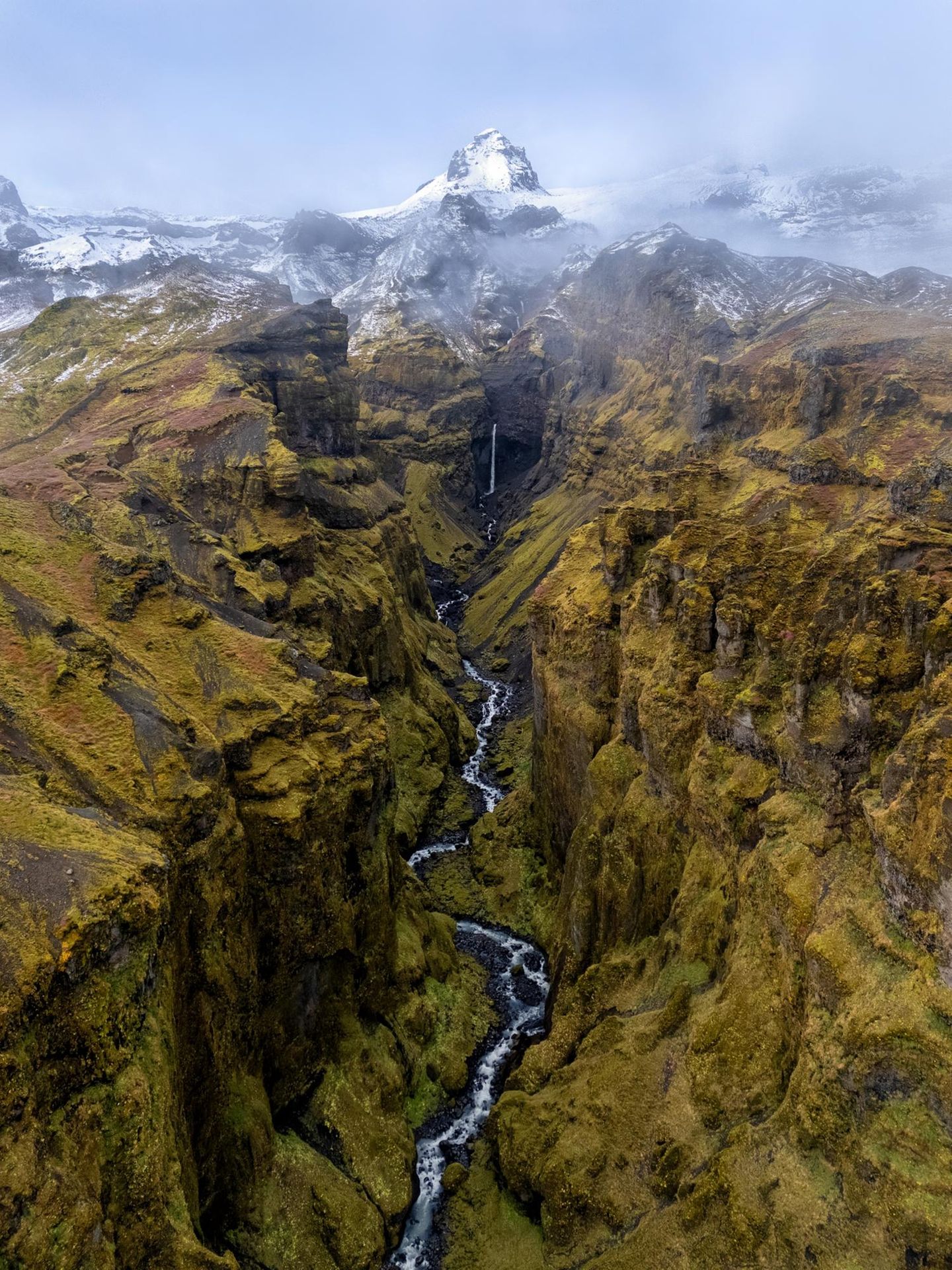 Dem deutschen Fotografen Timo Zilz gelingt es, die facettenreiche Landschaft Islands in einem einzigen Bild einzufangen: Ein Bach schlängelt sich durch sattgrünes Moos, während im Hintergrund schneebedeckte Berggipfel geheimnisvoll in den Nebel ragen.