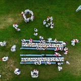 Eine traditionelle Hochzeit in Maramures, Rumänien: Familie und Freunde sind zusammengekommen, um in festlicher Tracht das junge Brautpaar zu feiern. Die preisgekrönte Aufnahme bietet einen Blick aus der Vogelperspektive auf die beiden prächtig gedeckten Tafeln, die den Mittelpunkt der Feier bilden.