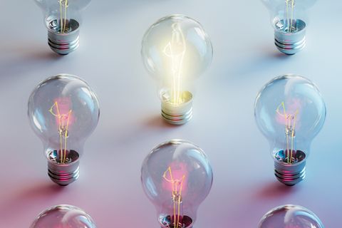 Eine leuchtende Glühbirne umgeben von nicht leuchtenden Glühbirnen