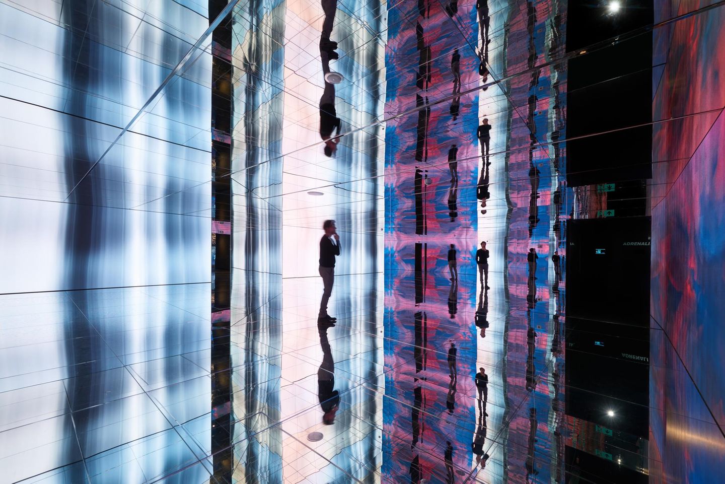 Person im Spiegelsaal des Museums, viele Lichteffekte