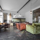 Ferienwohnung mit bunten Sesseln und modernen Holzskulpturen