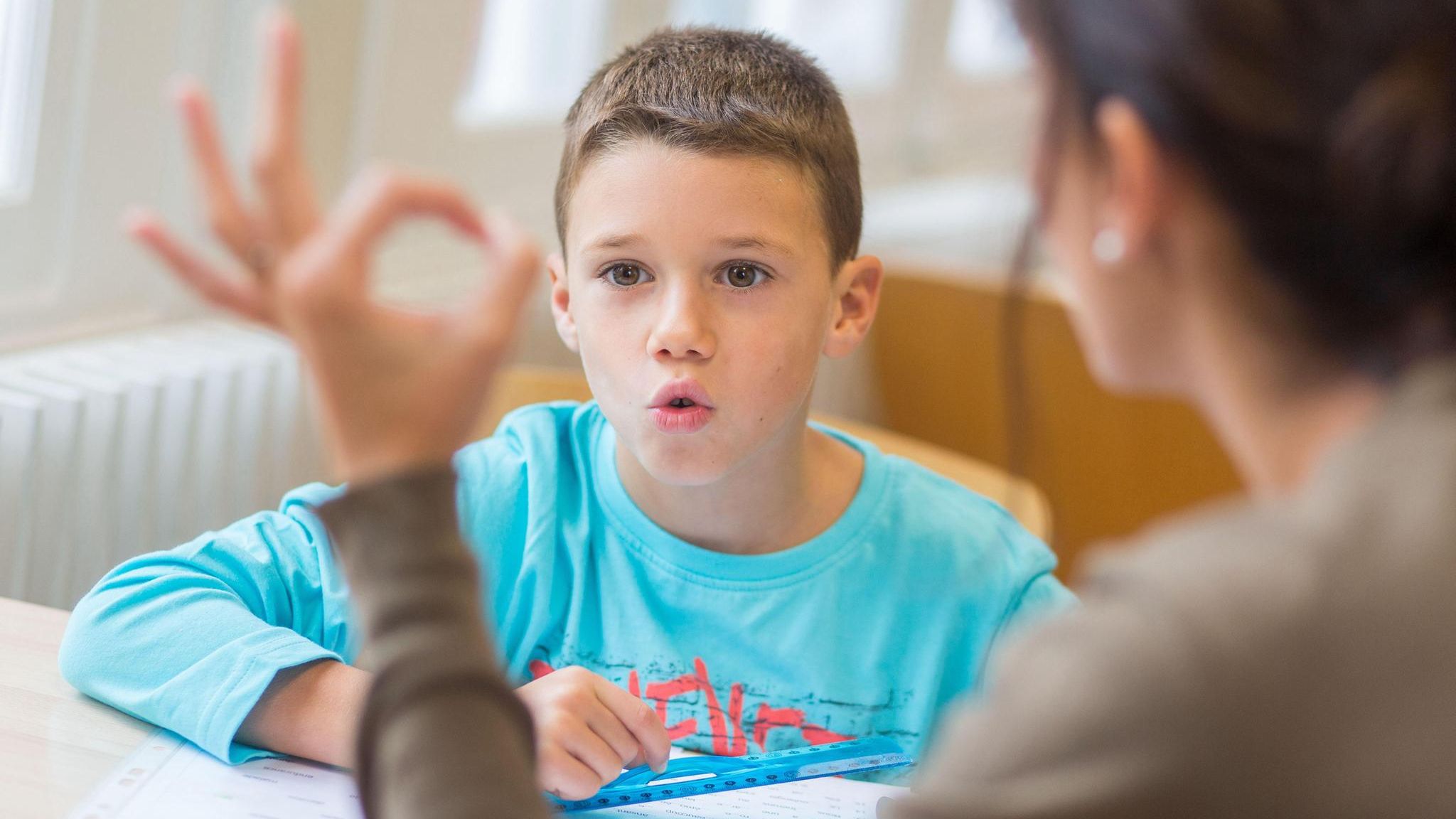 Eine Junge absolviert Sprechübungen mit einer Logopädin