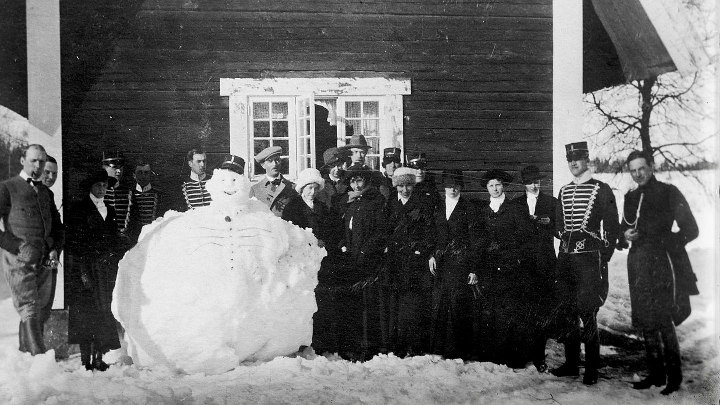 Antreten zum Dienst! Gruppe von Menschen posiert um Schneemann