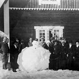 Gruppe von Menschen posiert um Schneemann