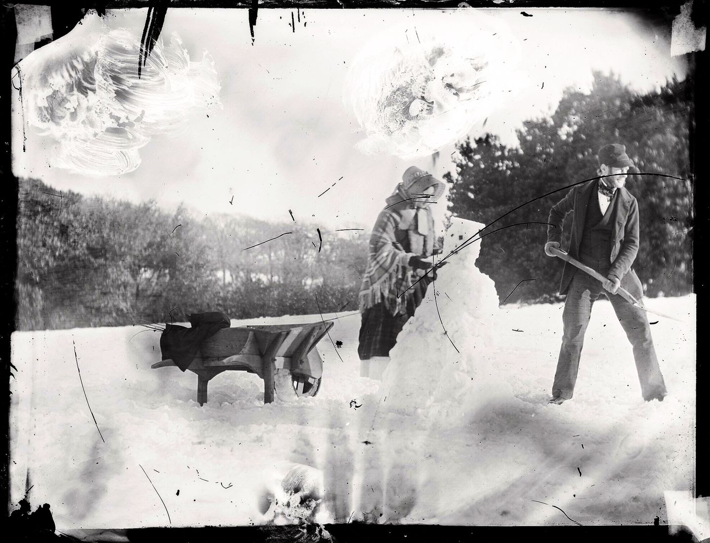 Das erste Schneemannfoto Frau und Mann schaufeln Schneemann