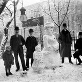 Menschen posieren vor Königin Wilhelmina als Schneefrau