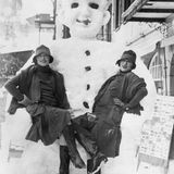 Zwei Frauen posieren vor Schneemann