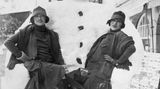 Zwei Frauen posieren vor Schneemann