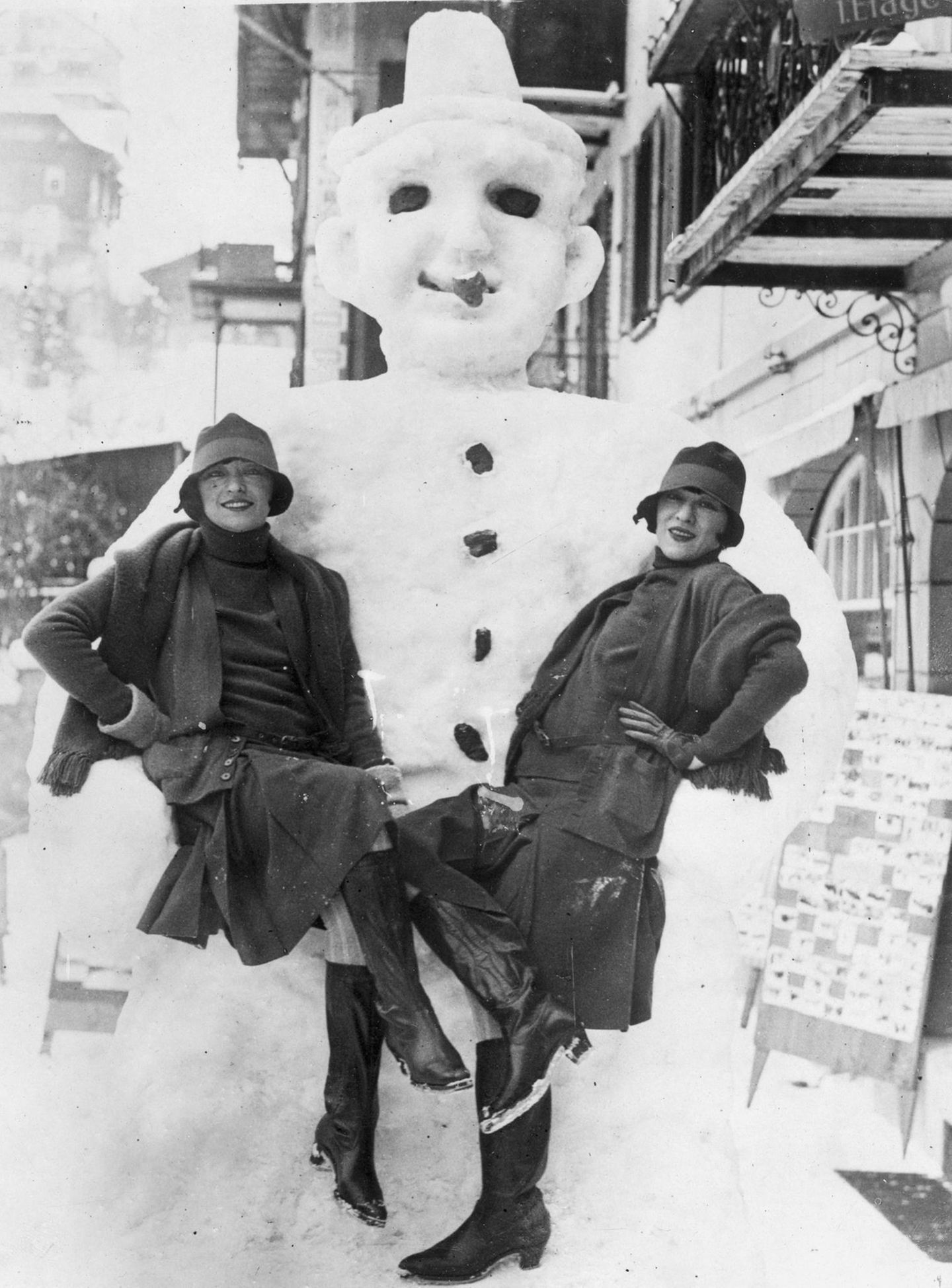 In eisigen Armen Zwei Frauen posieren vor Schneemann