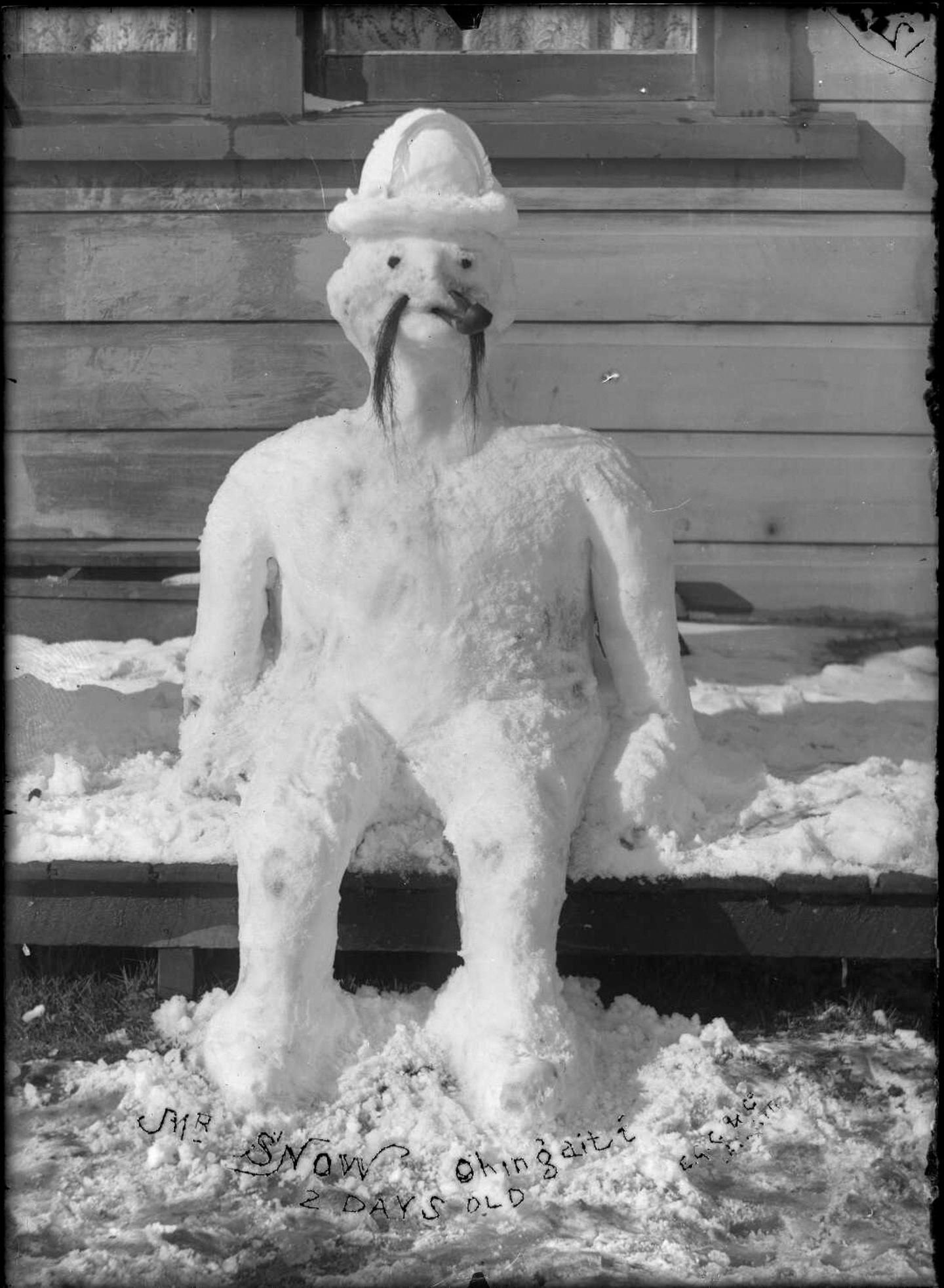 Schneemann sitzt auf Bank