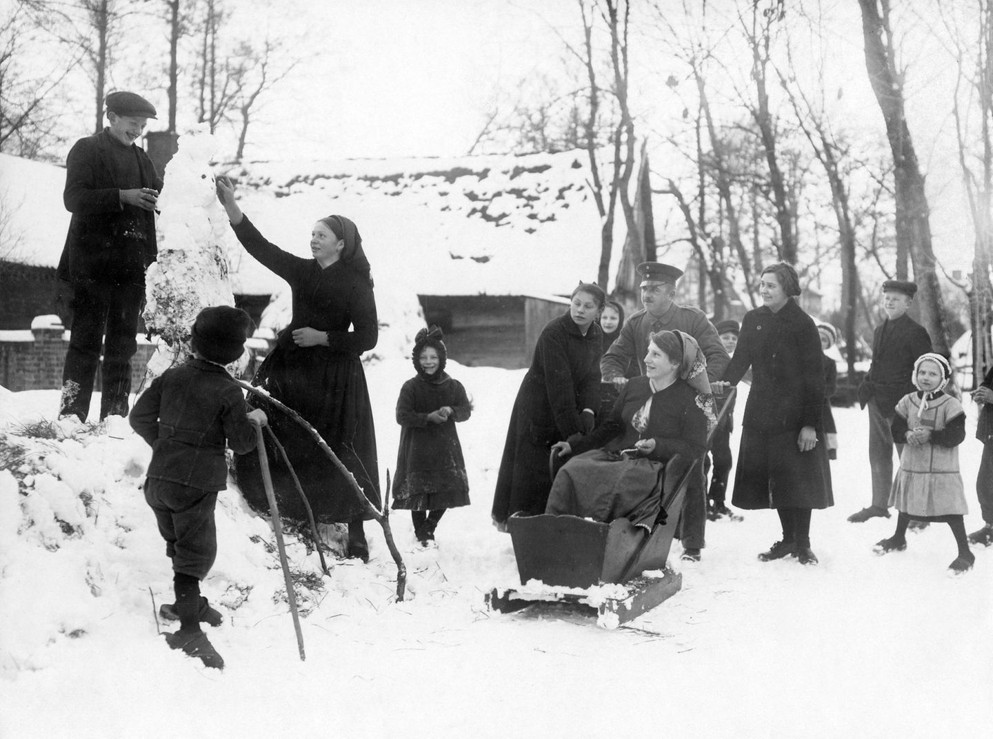 Knopfaugen ins Gesicht – und fertig ist der Schneemann! Dass die eisigen Gestalten Klein und Groß zusammenbringen, zeigt diese Aufnahme aus dem Spreewald (vermutlich 1910er-Jahre).