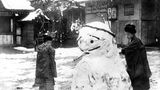 Zwei Japanerinnen bauen Schneemann