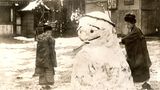 Zwei Japanerinnen bauen Schneemann