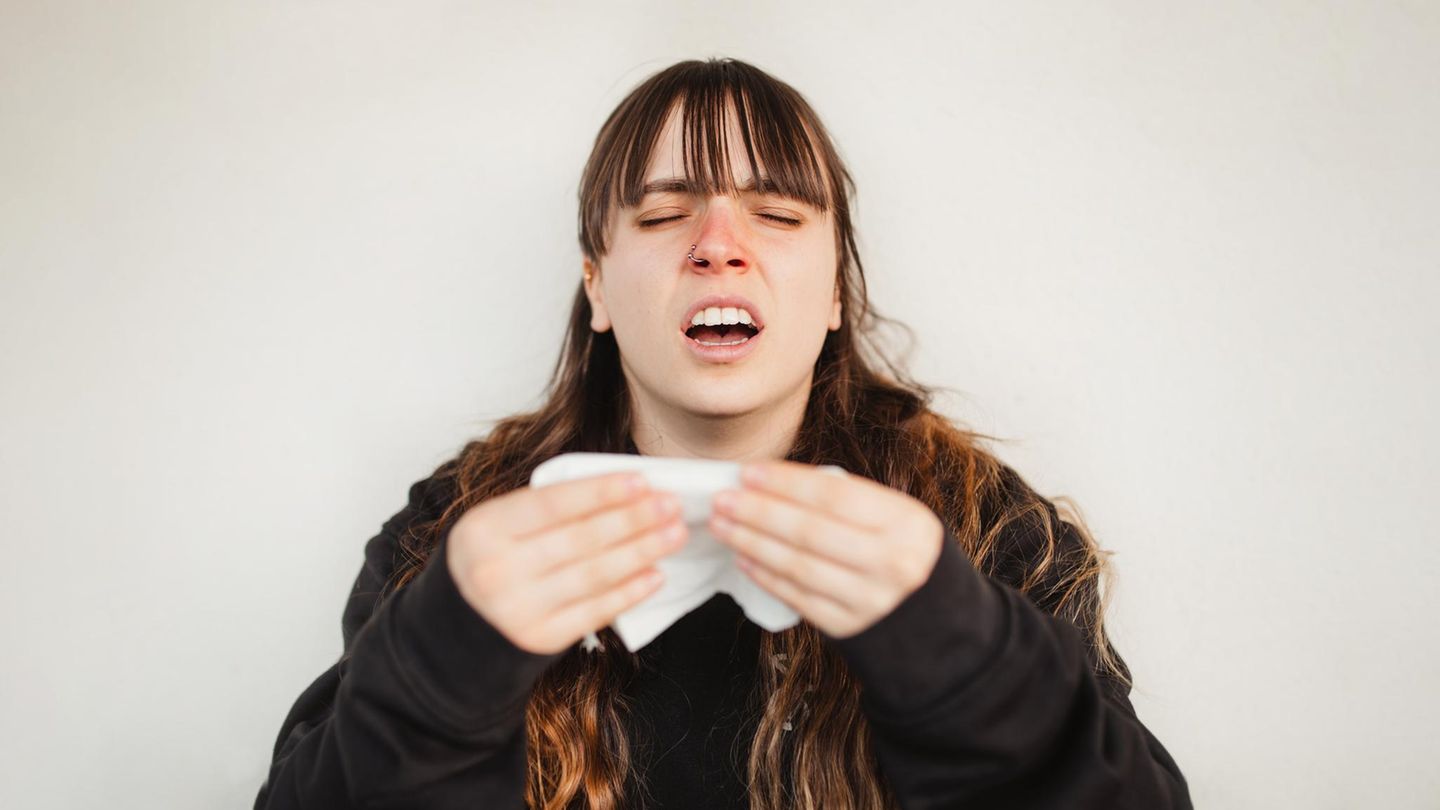 Eine Frau muss niesen