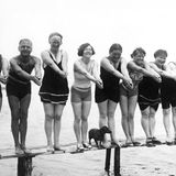 Neun Männer und Frauen und ein Dackel posieren auf einem Bootssteg, 1920er Jahre Usedom