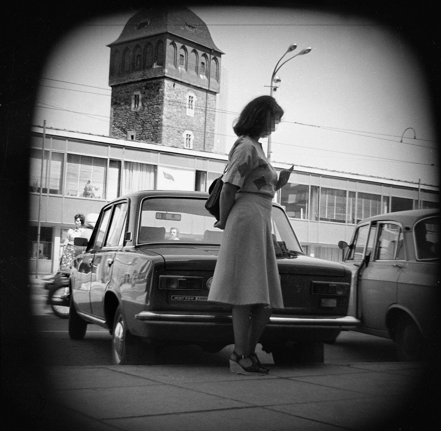 Frau wird vor einem Auto heimlich fotografiert