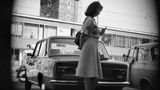 Frau wird vor einem Auto heimlich fotografiert