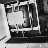 Mann quetscht sich in einem Hohlraum zusammen