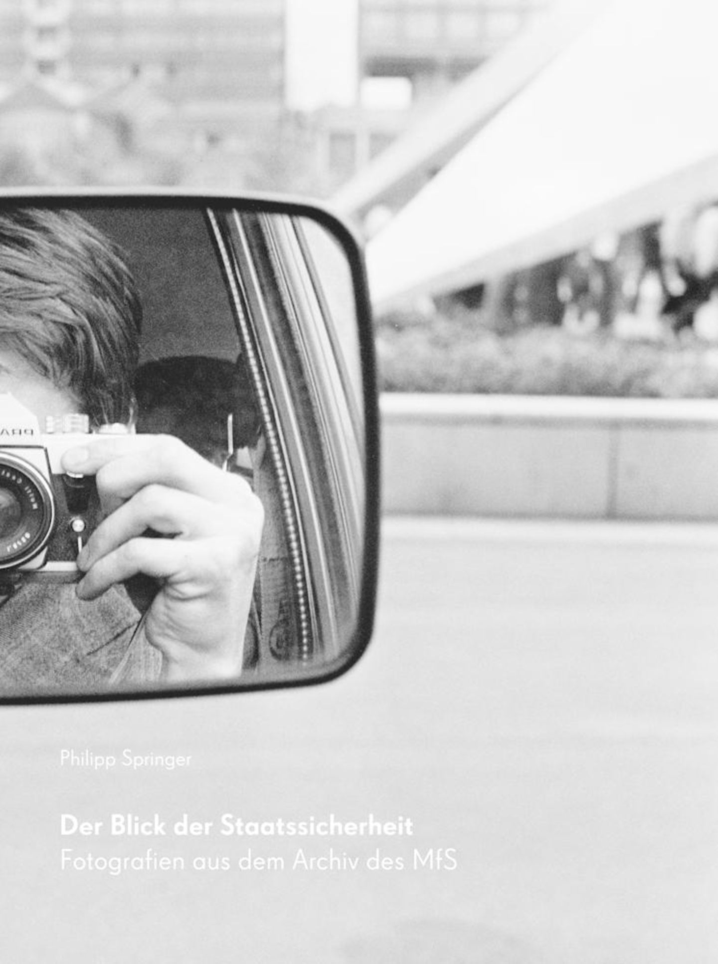 Buchcover zeigt Mann mit Kamera in einem Autospiegel