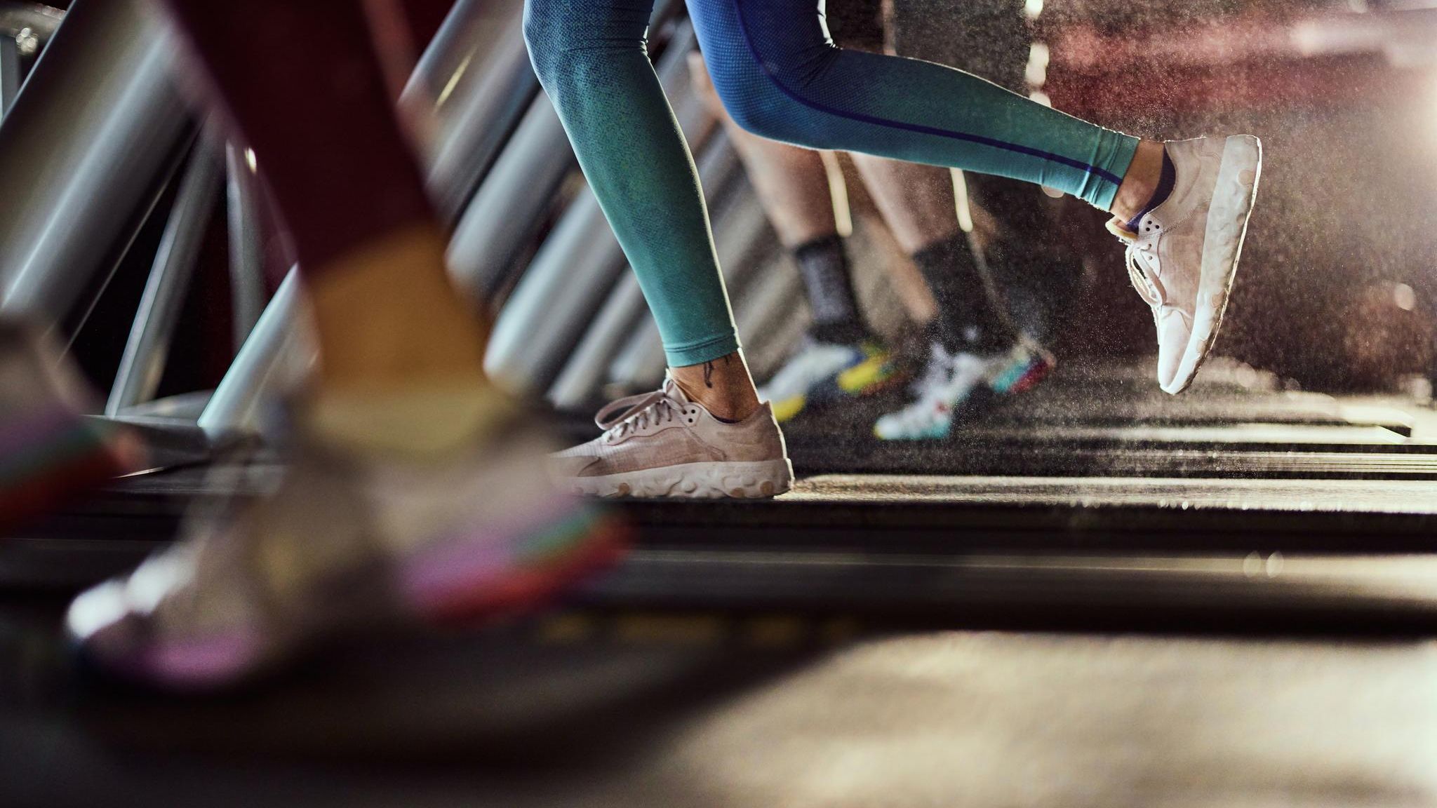 Unrecognizable athletic woman exercising on treadmill in a health club.