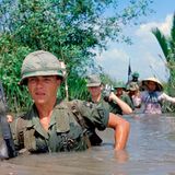 US-Soldat durchquert einen tiefen Bewässerungskanal zusammen mit Mitgliedern der 5th ARVN Ranger Group