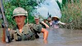 US-Soldat durchquert einen tiefen Bewässerungskanal zusammen mit Mitgliedern der 5th ARVN Ranger Group