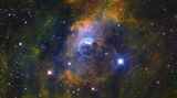 Der Blasennebel NGC 7635, vom deutsch-britischen Astronomen William Herschel 1787 entdeckt, entsteht durch einen extrem heißen Stern in der Mitte des Nebels: Dessen Wind trifft auf Gas zwischen den Sternen und drückt dieses zusammen. NGC 7635 gehört zu der häufigsten Kategorie kosmischer Nebel: den Emissionsnebeln. Es handelt sich um verdichtete kosmische Gas- und Staubwolken, deren Gas zunächst durch das Licht von Sternen in ihrer Umgebung angeregt wird und anschließend selbstständig Licht emittiert.