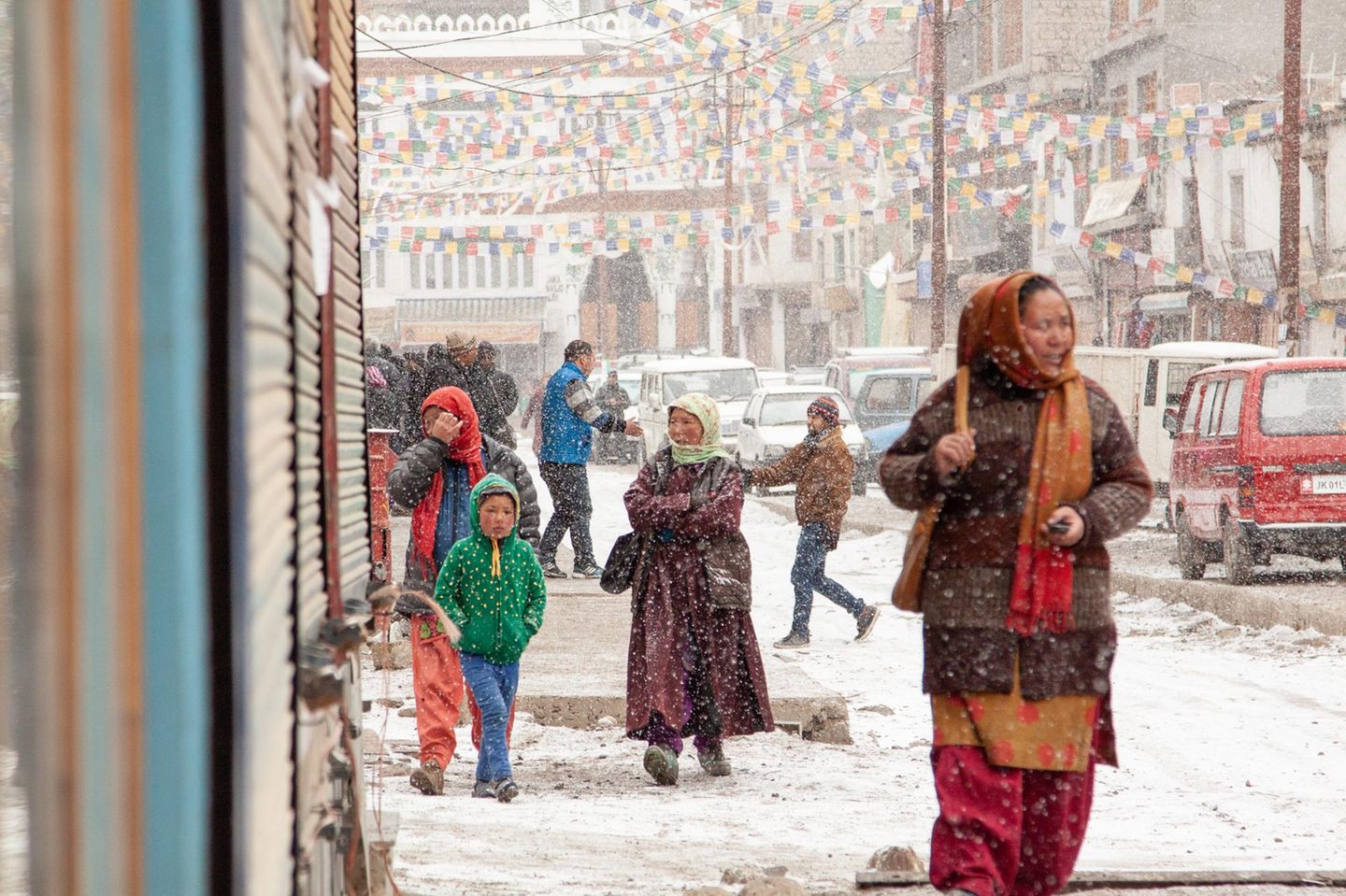 Die Fragilität des Schnees Personen laufen durch eine winterliche Stadtlandschaft