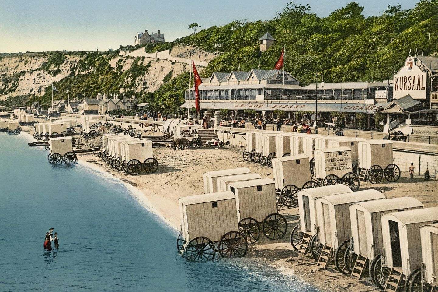 Am Strand vor dem Kursaal im Seebad Sandown sorgen überdachte Wagen dafür, dass Badegäste ungestört und sittsam ihre Badekleidung anziehen und im Meer baden gehen können. 