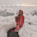 Eine Frau steht inmitten von toxischem Schaum in einem Fluss