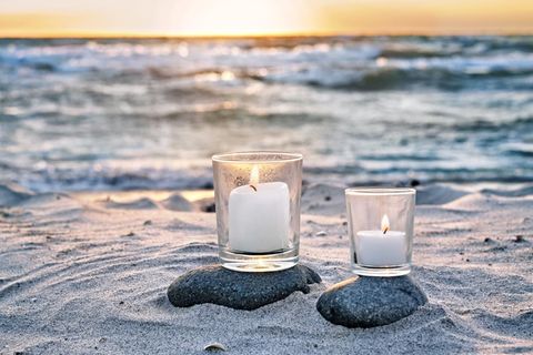 Kerzen am Strand im Sonnenuntergang