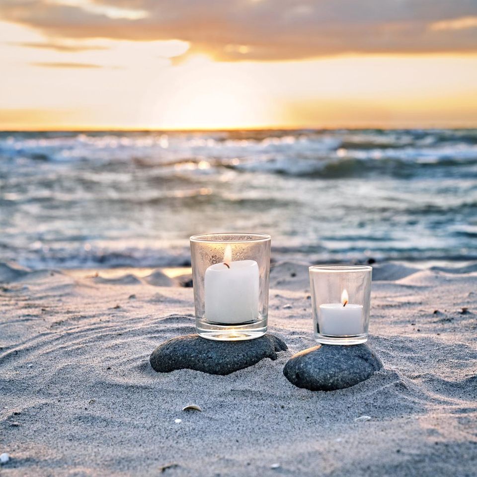 Kerzen am Strand im Sonnenuntergang