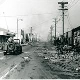 Jeep fährt durch zerstörtes Viertel