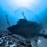 Im Roten Meer, Ägypten, gelang diese Aufnahme von einem gesunkenen Schiffswrack in knapp über 100 Meter Tiefe. Es liegt so auf zwei Riffen, dass die Taucher darunter durchtauchen können.