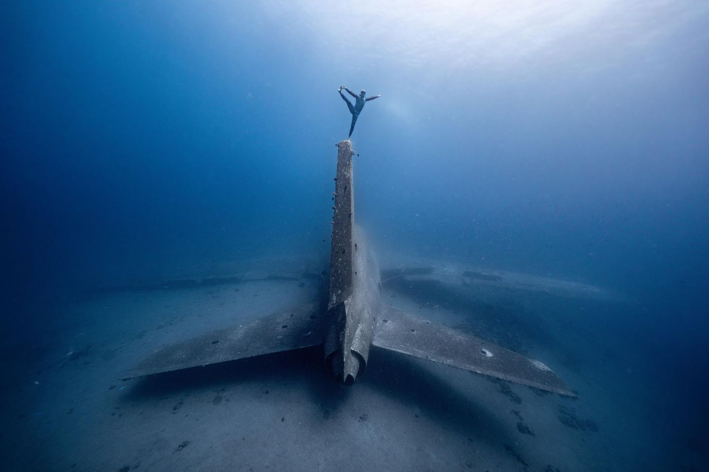 Im Golf von Akaba, Jordanien, gelang dieser Schnappschuss von einem auf dem Seitenruder eines versunkenen Lockheed-Jets balancierenden Freediver.