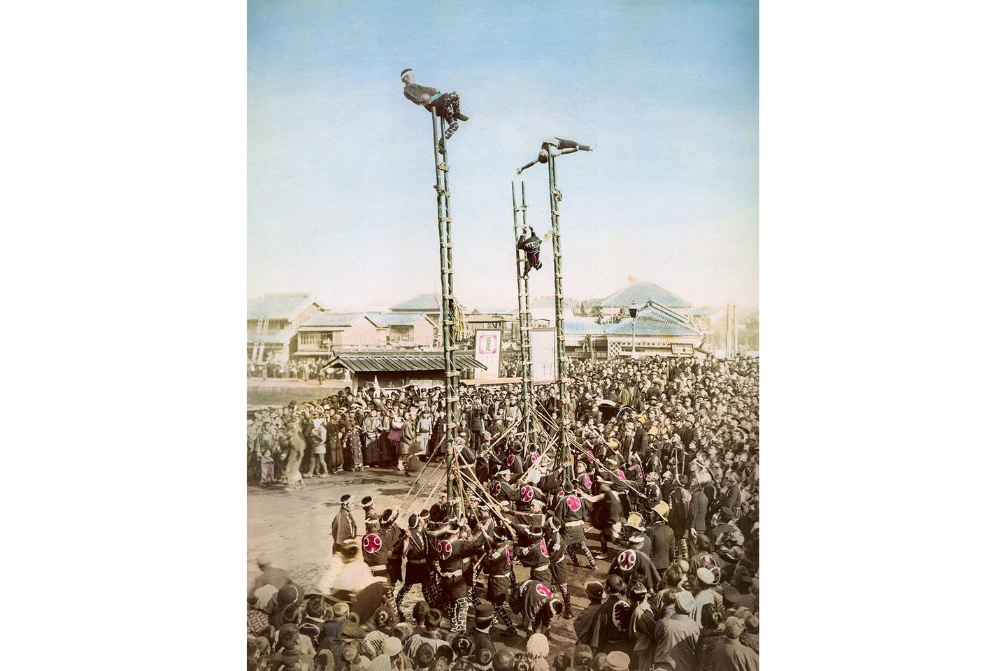 Hier sind nicht etwa Akrobaten oder Schausteller zu sehen: Stattdessen zeigt die Abbildung das Dezome-Shiki, eine spektakuläre Neujahrsvorführung der Feuerwehrleute von Edo. Die Tradition gibt es bis heute, obwohl im heutigen Tokio bereits 1880 eine Feuerwehr im westlichen Stil etabliert wurde.