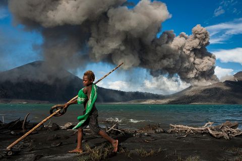 Tavurvur, Papua-Neuguinea  Munganau kennt nichts anderes als das  Leben mit dem Tavurvur. Seit­ dem er auf der  Welt ist, spuckt der Vulkan fast täglich Asche,  Lavabomben und lässt den Himmel nachts  leuchten.
